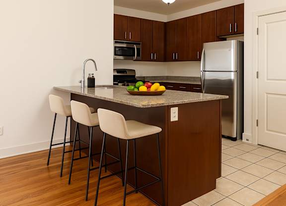 A kitchen with a refrigerator, microwave, and oven.