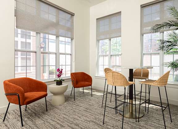 Resident lounge with sleek finishes, tall windows, and comfortable seating at Bridgepoint in Bayonne NJ