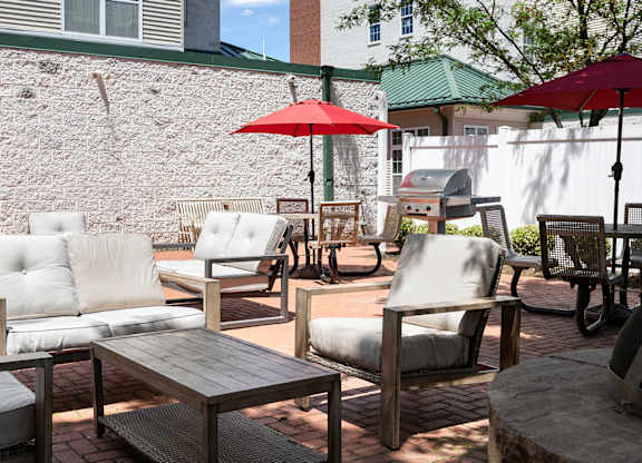Comfortable resident courtyard at Bridgepoint apartments with grill stations, shaded seating, and modern outdoor furniture