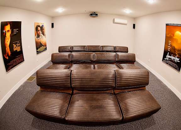 a theater room with large brown leather seating at The Lofts at Middlesex, the perfect in  house cinema