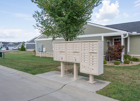 A mailbox with a tree in front of a house.