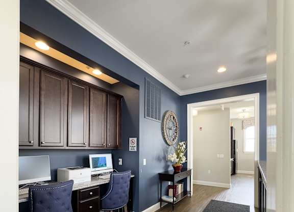 Stylish business center at Queens Gate Apartments featuring modern workstations, comfortable seating, and a sleek design—perfect for remote work and productivity