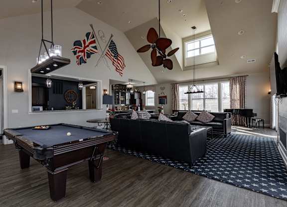 Elegant clubhouse at Queens Gate Apartments featuring a pool table, cozy lounge area, and stylish decor.