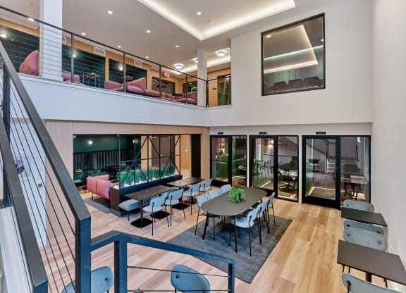 Spacious multi-level common area at The Mint Rahway featuring seating and tables, perfect for social gatherings, near Rahway Train Station and Newark Airport.