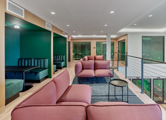 Cozy lounge with pink and green seating at The Mint Rahway, a luxury apartment rental near Rahway Train Station and Newark Airport.