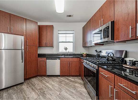 a kitchen with wooden cabinets and stainless steel appliances