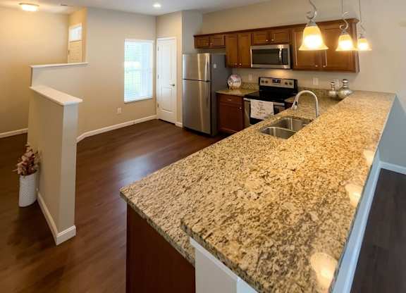 A kitchen with granite countertops and stainless steel appliances.
