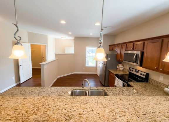 A kitchen with granite countertops and stainless steel appliances.