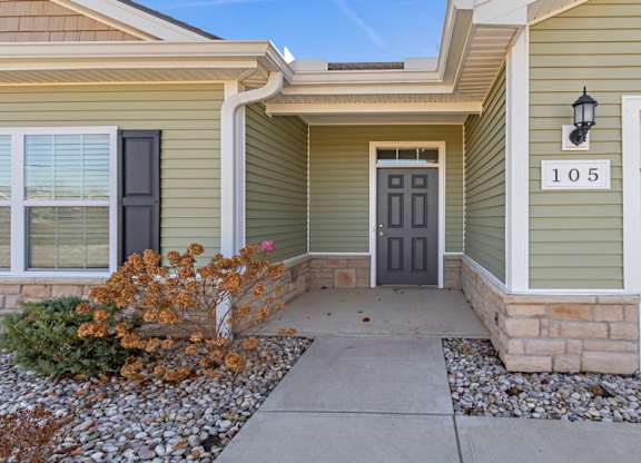 A house numbered 105 with a grey front door and a small front garden.