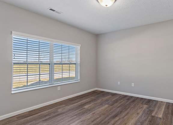 A room with wooden flooring and a window with blinds in The Villages of Florence and Weaver Mill home rentals