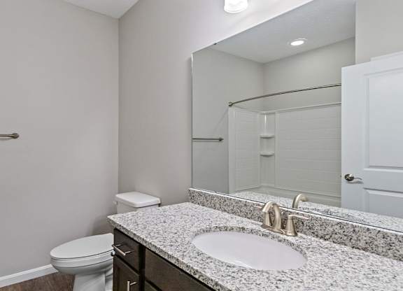 Bathroom with large mirror and granite counters in an apartment for rent in Florence, KY