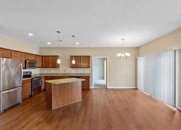 A kitchen with wooden floors and stainless steel appliances in a ranch-style home rental in Florence, KY