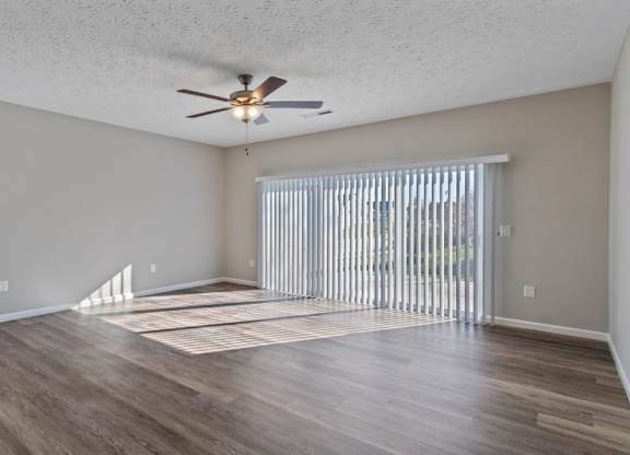 A room with a ceiling fan and sliding glass doors at The Villages of Florence and Weaver Mill