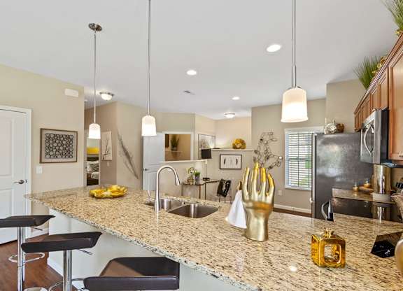 A kitchen with granite countertops and a bar area in a ranch-style home for rent in a private Florence, KY community