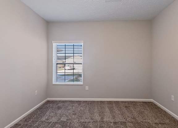 A room with a window and carpeted floor for cozy days at The Villages of Florence and Weaver Mill
