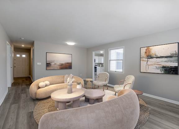 A spacious living room at The Village at Bridgewater in Bridgewater, NJ. Open floor plan with large windows, neutral walls, and wood-style flooring for a modern touch.
