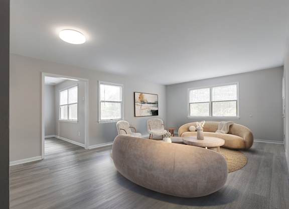 A bright and airy living space at The Village at Bridgewater in Bridgewater, NJ. Features multiple windows, neutral walls, and a seamless connection to adjacent rooms for an open feel.