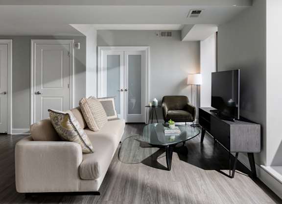 A sun-lit, modern living room showcasing the open-concept design of apartments in Rittenhouse Square Philadelphia PA.