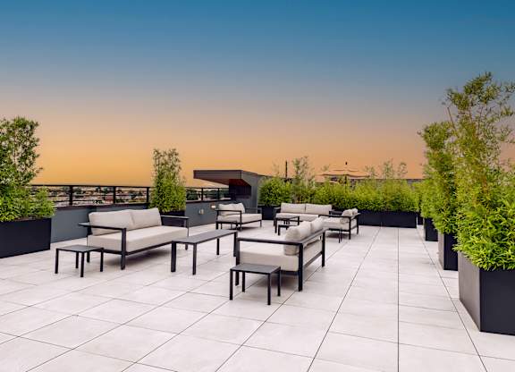Modern rooftop lounge with cushioned seating at The Botanic apartments in Carteret, NJ