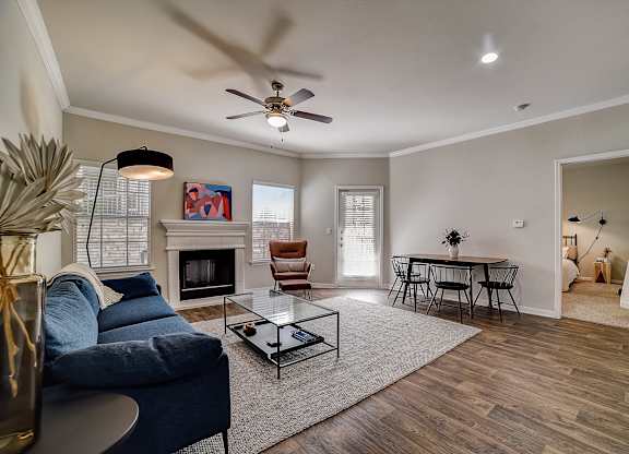 Bright living and dining area with patio door, fireplace, and bedroom hallway.