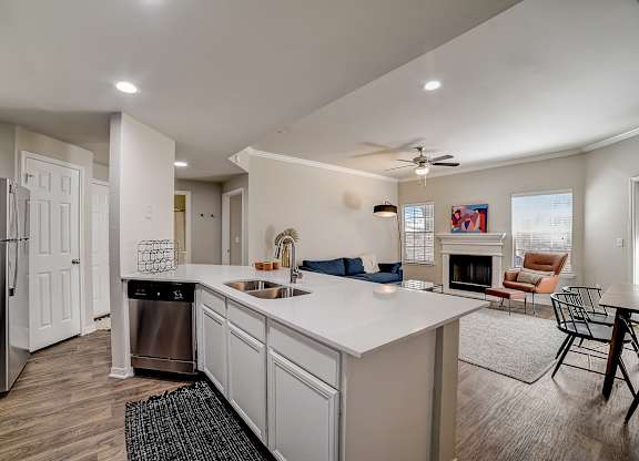 La Mirage in San Antonio open-concept kitchen island with double sink overlooking fireplace lounge.
