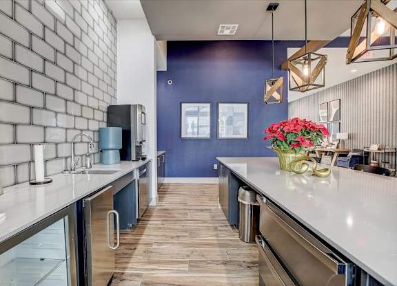 Community kitchenette with subway tile backsplash, beverage station, and stainless mini fridge for refreshments.