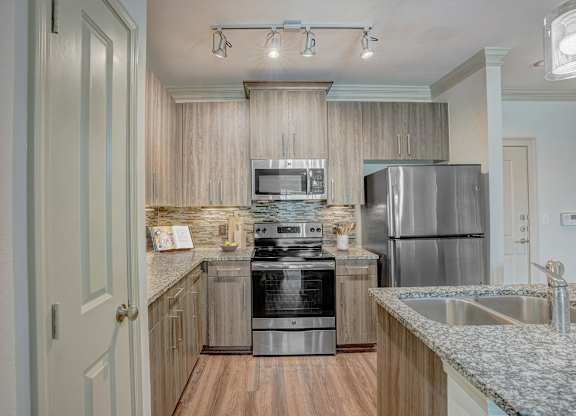 a kitchen with granite counter tops and stainless steel appliances