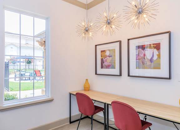 A table with two chairs and two hanging lights.