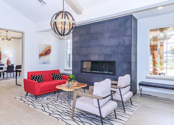 A modern living room with a red couch and a fireplace.