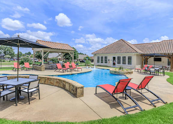 A poolside area with a table and chairs.