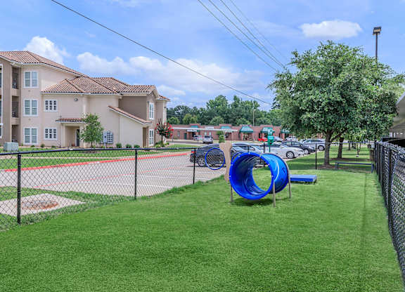 A playground with a blue slide and a baseball diamond.