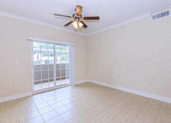 A room with a ceiling fan and tiled floor.