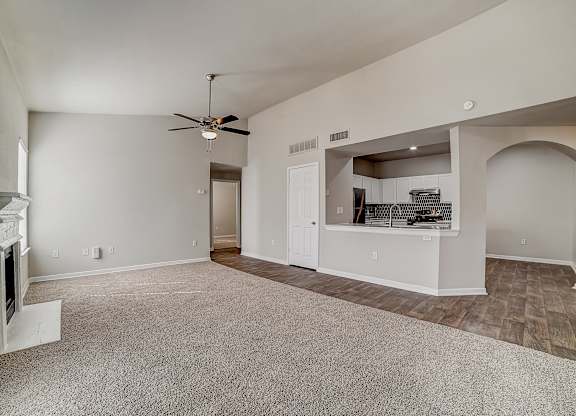 Open living room with breakfast bar pass-through and arched hallway entrance.