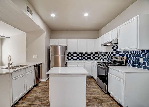 Updated kitchen layout with central island, recessed lighting, and stainless appliances.