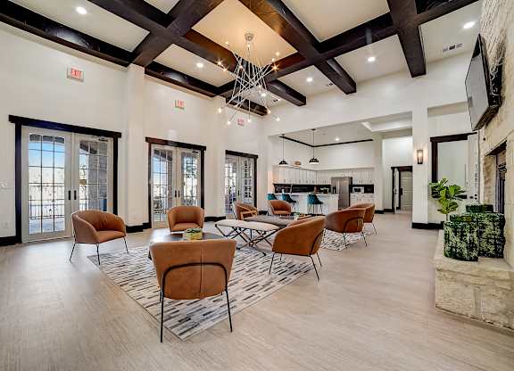 Resident clubhouse seating with French doors, high ceilings, and adjoining kitchen space.