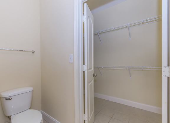 A white toilet sits next to a white door in a bathroom.