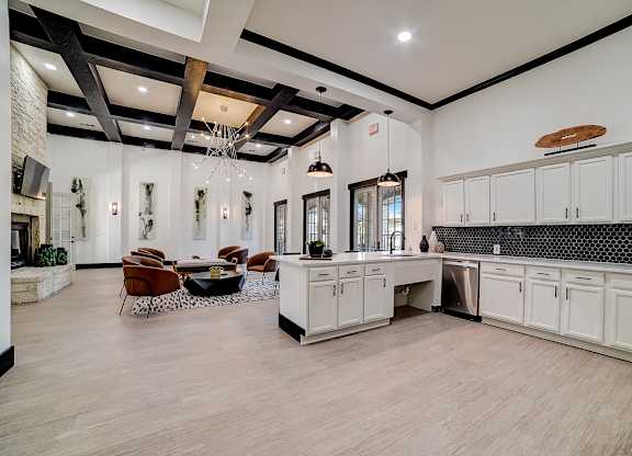 Clubhouse entertaining kitchen with large island, pendant lights, and lounge seating.