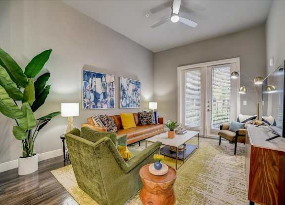 A living room with a green couch and a television.