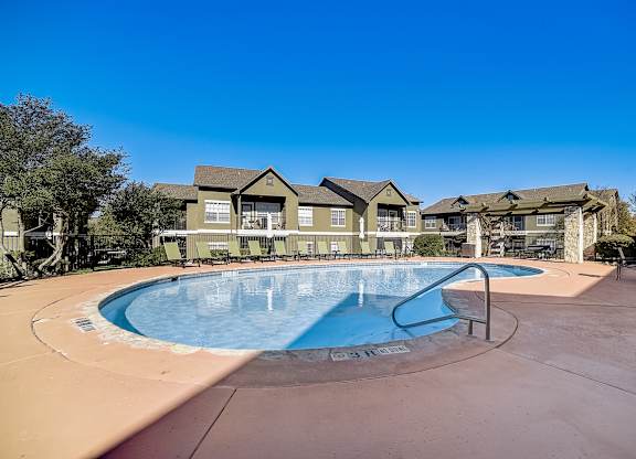 La Mirage in San Antonio resort-style pool with lounge chairs and nearby pergola.