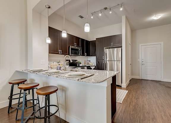 A kitchen with a bar area and stools.
