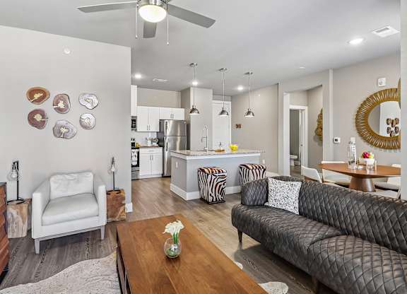 A modern living room with a grey couch, a white chair, and a wooden coffee table.