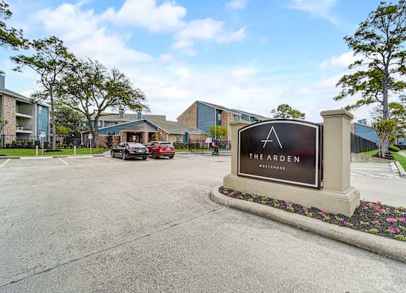 the arden apartments entrance sign with parking lot and buildings