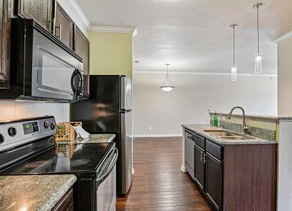 A kitchen with black appliances and a granite countertop.
