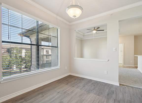A room with a ceiling fan and a window with blinds.
