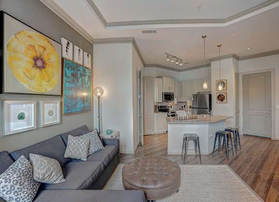 a living room with a couch and a kitchen with a bar