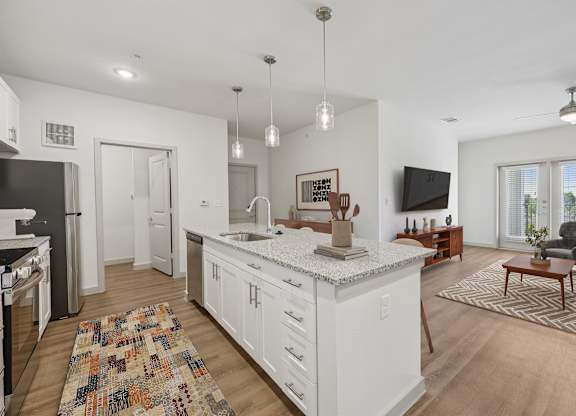 A kitchen with white cabinets and a granite countertop.