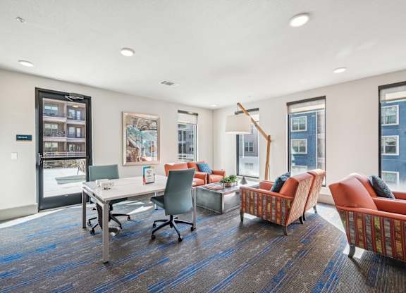 A room with a desk, chairs, and a bookshelf.