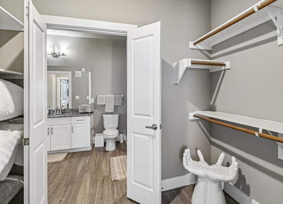 A white toilet is in a small bathroom with a bunk bed.