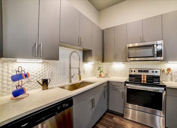 A modern kitchen with a stove top oven and a microwave above the stove.
