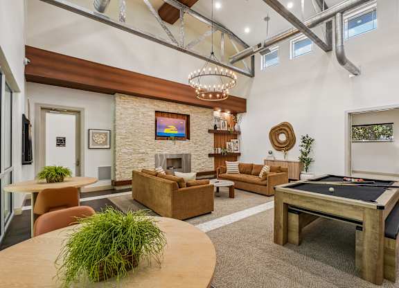 A living room with a pool table and a fireplace.
